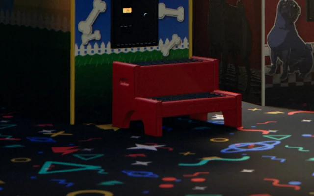 Close-up: a red step stool in front of a game cabinet